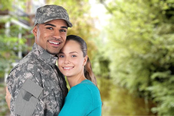 En soldat som klemmer kona si – stockfoto