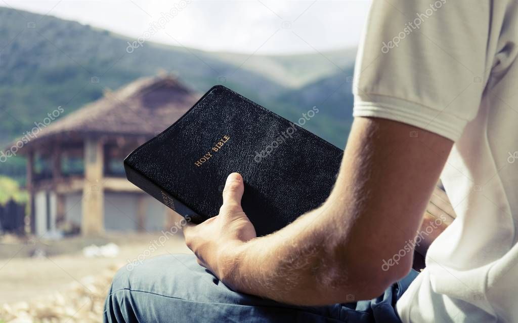 Man holding  bible book 