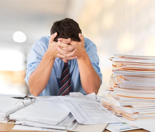 Jeune homme d'affaires avec pile de papiers — Photo