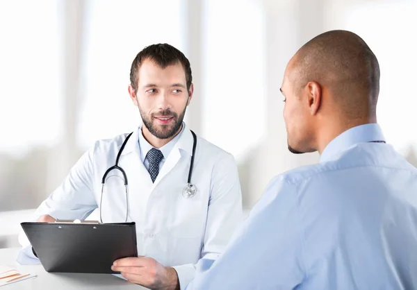 Médico sorrindo com paciente do sexo masculino — Fotografia de Stock