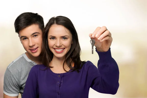 Joven pareja sosteniendo llave — Foto de Stock