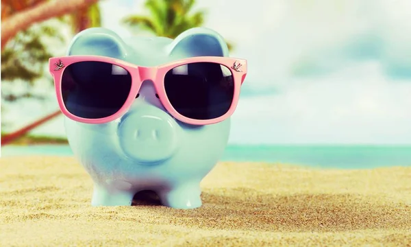 Piggy bank with sunglasses on the beach — Stock Photo, Image