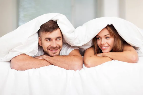 Junges Paar im weißen Bett — Stockfoto