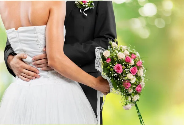 Bride and groom holding stylish bouquet — Stock Photo, Image