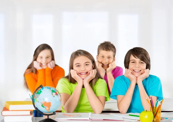 Niños sentados junto a la mesa —  Fotos de Stock