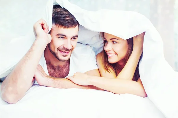Νεαρό ζευγάρι στο κρεβάτι white — Φωτογραφία Αρχείου