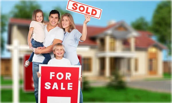 Ευτυχισμένη οικογένεια με προς πώληση σημάδι — Φωτογραφία Αρχείου