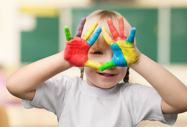 Little girl showing painted hands — Stock Photo, Image