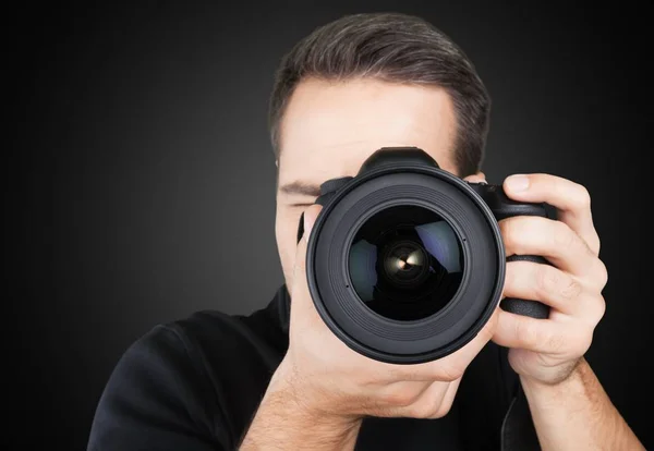 Fotógrafo olhando através da câmera — Fotografia de Stock