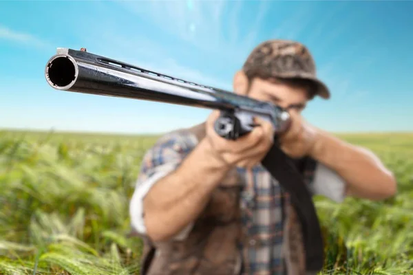 Caçador com arma no campo — Fotografia de Stock