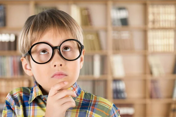 Menino de óculos pensando — Fotografia de Stock