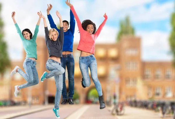 Gruppen Unga Studenter Hoppa Bakgrunden — Stockfoto
