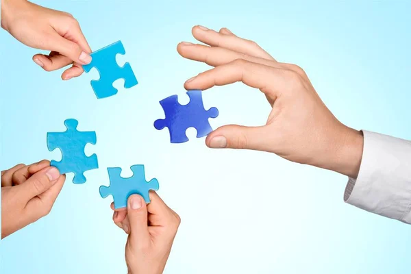 Hands joining puzzle parts — Stock Photo, Image