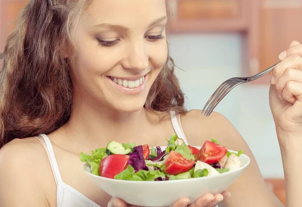 Mulher segurando salada e sorrindo — Fotografia de Stock