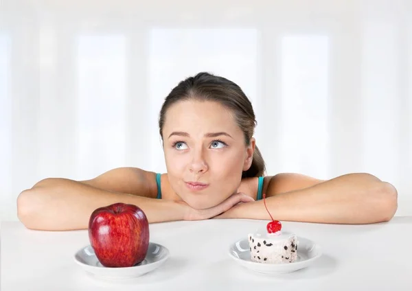 Žena dělá volbou mezi apple a dort — Stock fotografie