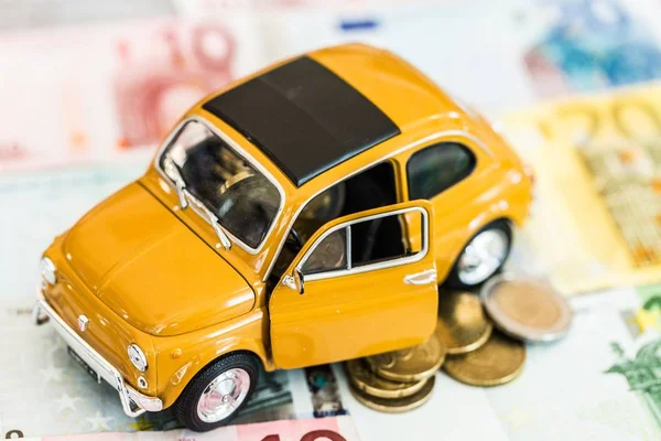 Coche amarillo con dinero — Foto de Stock