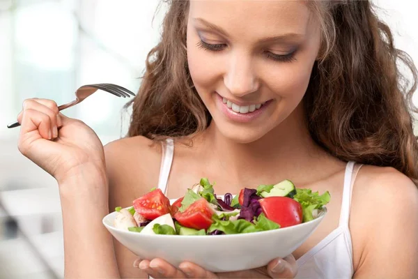 Mulher segurando salada e sorrindo — Fotografia de Stock