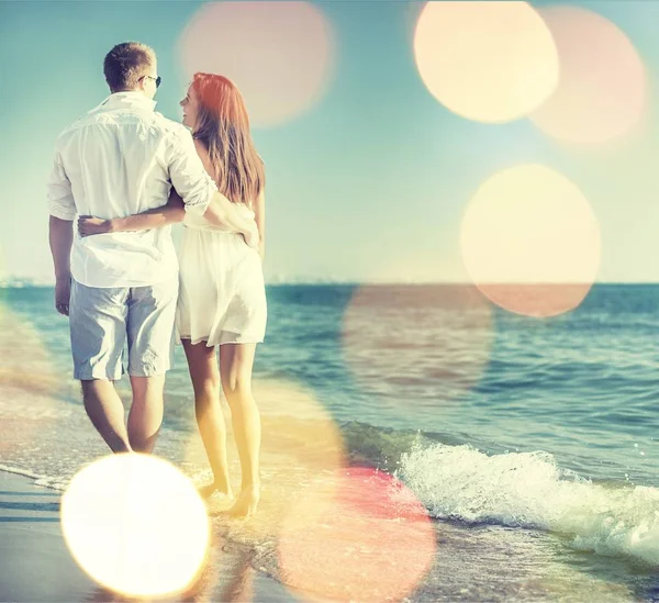 幸せなカップルがビーチを歩き — ストック写真