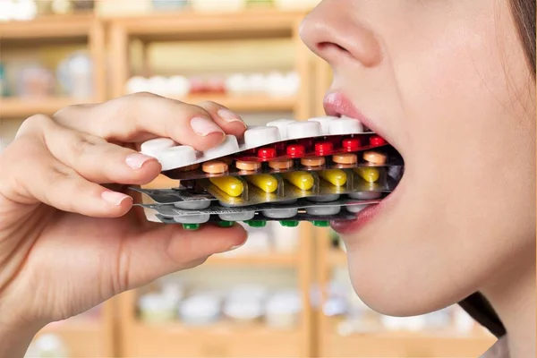 Девушка ест много таблеток — стоковое фото