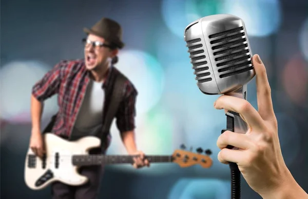 rock star singing with guitar and microphone