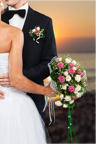 Braut und Bräutigam halten Blumenstrauß — Stockfoto