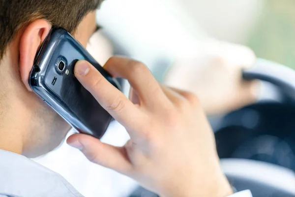 Бизнесмен с помощью мобильного телефона в машине — стоковое фото