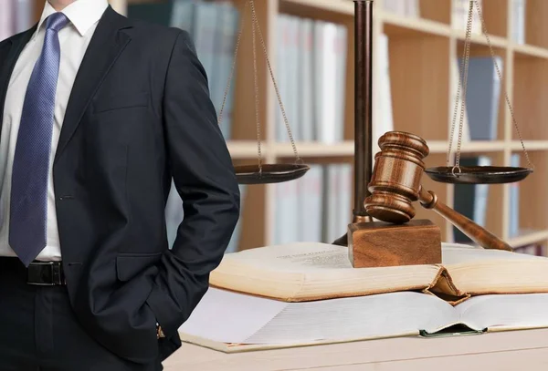 Man met boeken en houten hamer. — Stockfoto