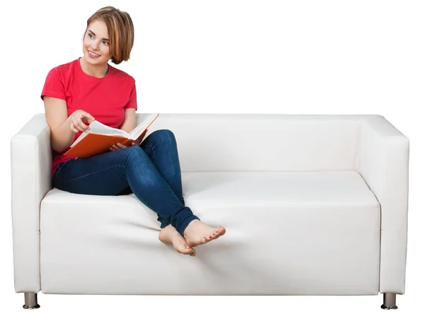 Žena číst knihu na pohovce — Stock fotografie