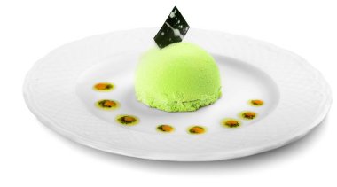 Beyaz tabak beyaz arka plan üzerinde izole lezzetli yeşil dondurma yakın çekim