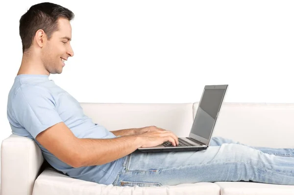 Homem relaxante no sofá com um laptop — Fotografia de Stock