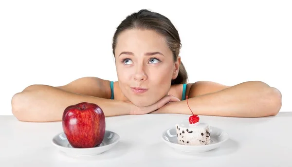 Woman choosing between apple and cake — Stock Photo, Image