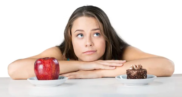 Femme au choix entre pomme et gâteau — Photo