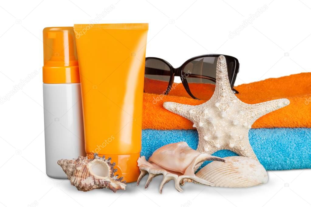 seashell and cream on blue and orange towel background. Travel concept