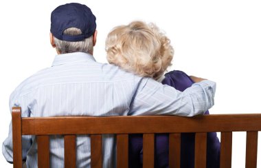 Beyaz arka plan üzerinde izole bankta oturmuş kıdemli Çift 