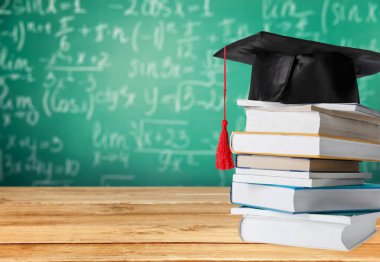 Mezuniyet şapka ve kitap yığını