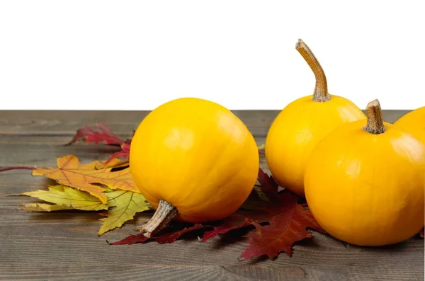 Calabazas y hojas sobre mesa de madera —  Fotos de Stock