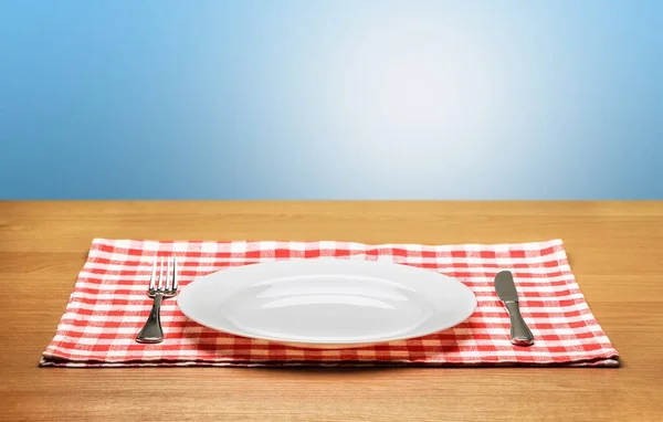 Белая тарелка на салфетке — стоковое фото