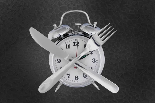 diet  concept with a fork and knife,clock with numbers as eating time or fast food entertainment