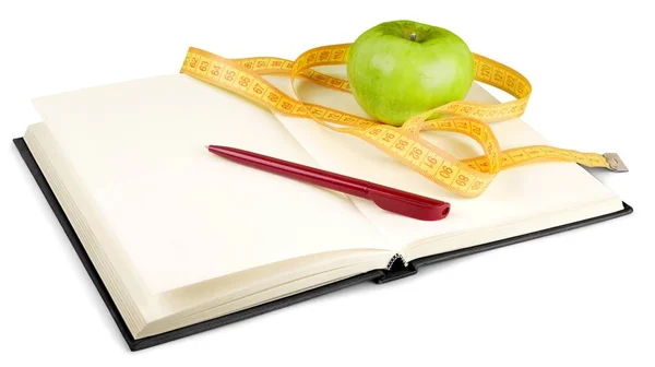 測定テープと白で隔離のノートブックで新鮮なリンゴ ストックフォト