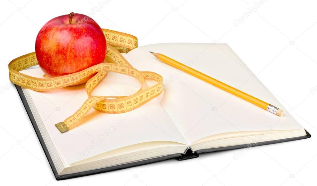 Fresh apple with measuring tape and notebook isolated on white 