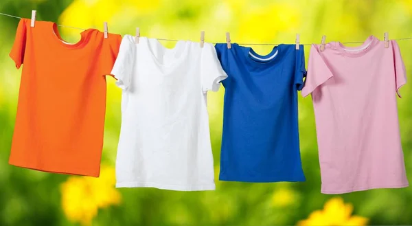 T-shirts coloridas penduradas na corda — Fotografia de Stock