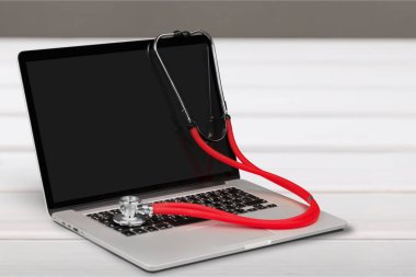 Modern dizüstü ve ahşap arka plan üzerinde stetoskop