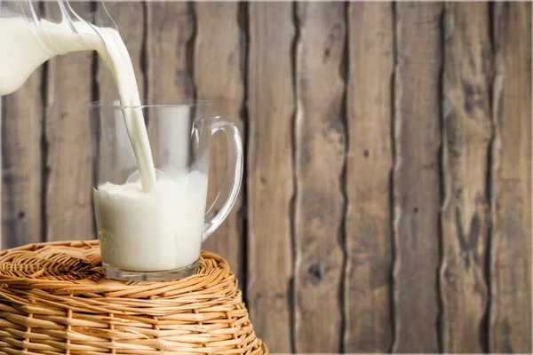 Milch in Glas gießen — Stockfoto