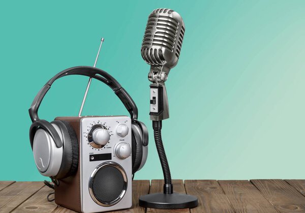 Microphone, radio and headphones on wooden table 