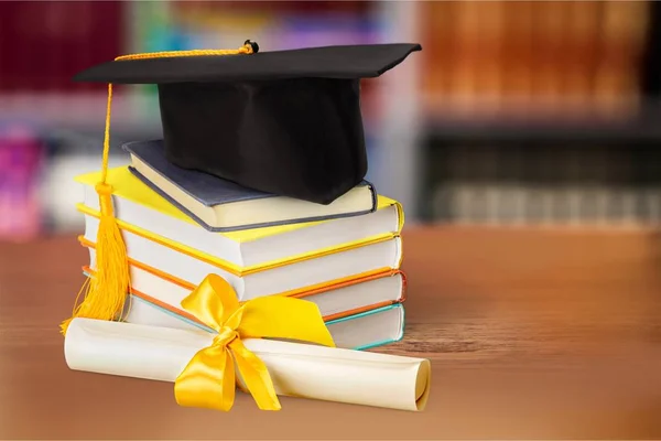 Graduation hat on stack of books — Stock Photo, Image