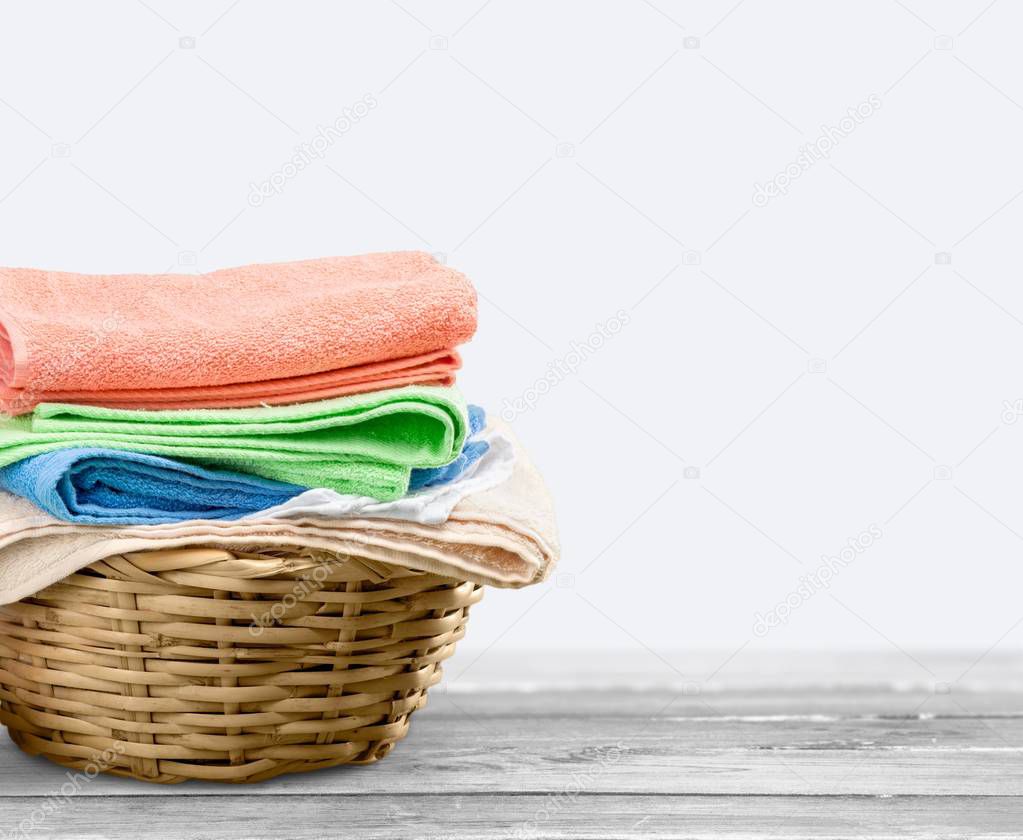 Pile of fluffy towels  and wicker basket 