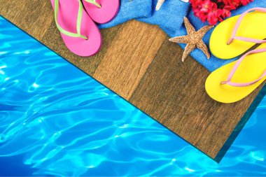 plaj aksesuarları ahşap tahta üzerinde Close-Up. Parmak arası terlik, deniz yıldızları, havlu