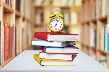 Kitaplar ve çalar saat üzerinde arka izole yığını