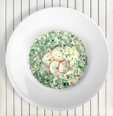 Ahşap arka plan üzerinde beyaz tabak içinde mantar çorbası