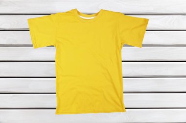 Ahşap arka plan üzerinde boş sarı tişört 